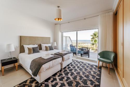 1 dormitorio con cama y vistas al océano en Beachfront Atlantic View A09, en Óbidos