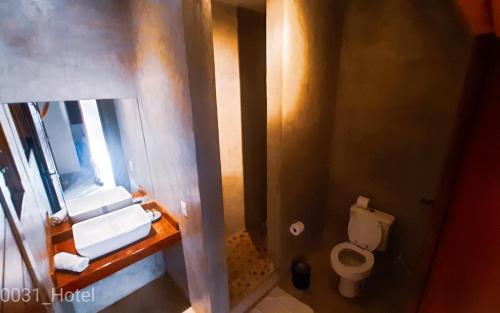 a bathroom with a toilet and a sink and a mirror at 0031 Boutique Hotel & Restaurant Cumbuco in Cumbuco