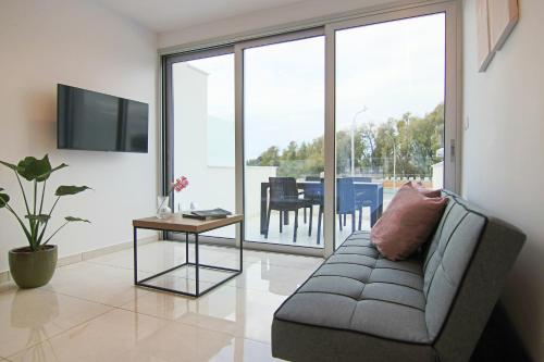 ein Wohnzimmer mit einem Sofa und einem Tisch in der Unterkunft Phaedrus Living - Seaside Luxury Flat Harbour 104 in Paphos