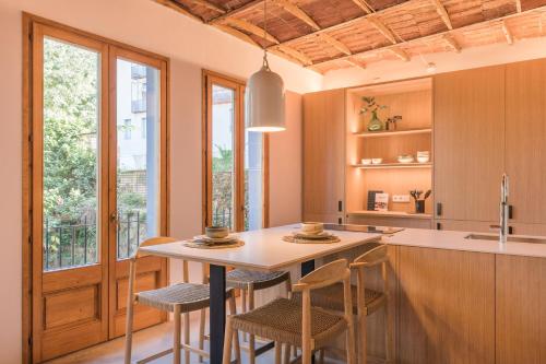 cocina con mesa, sillas y barra en LaComuna City Oasis, en Girona