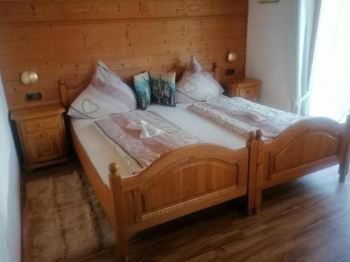 Schlafzimmer mit einem Holzbett und Holzboden in der Unterkunft Sonne in Halblech