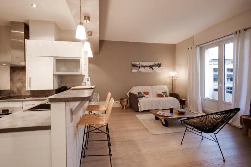 uma sala de estar com uma cozinha e uma sala de estar com uma cama em Le Sommeiller - Apartment for 2-4 people with balcony in the center em Annecy