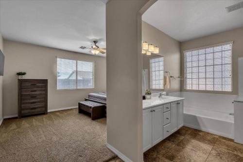 ein weißes Badezimmer mit einem Waschbecken, einer Badewanne und einem Waschbecken in der Unterkunft Cozy on Jerome in Mesa