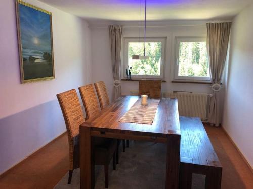 a wooden dining room table with chairs in a room at Große Ferienwohnung am Badesee in Erzgrube