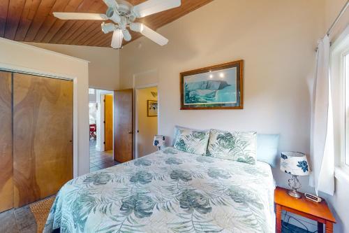 a bedroom with a bed and a ceiling fan at Waipio Glass House in Kukuihaele