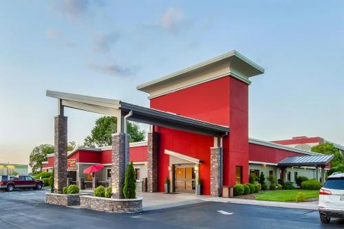 un edificio rojo con un coche aparcado en un estacionamiento en Days Inn & Suites by Wyndham Johnson City en Johnson City