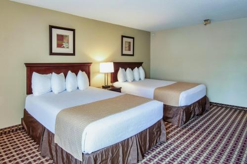 a room with two beds in a hotel room at Days Inn & Suites by Wyndham Johnson City in Johnson City