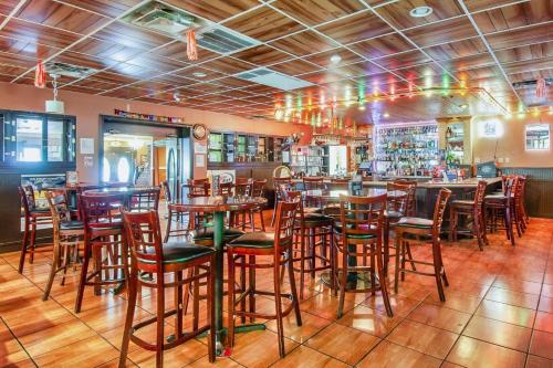 un restaurante con mesas y sillas de madera y un bar en Days Inn & Suites by Wyndham Johnson City en Johnson City