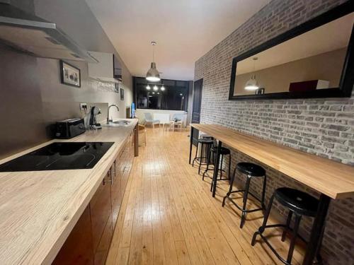 une cuisine avec un comptoir et un bar avec tabourets dans l'établissement Reims Hyper-Centre Erlon Cathédrale Calme, à Reims