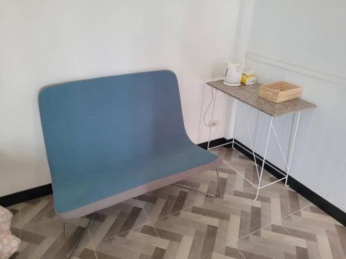 a blue chair in a room with a table at Baan Klang Khao Mountain Viewบ้านกลางเขา เมาเทนวิว in Ban Pang Asok