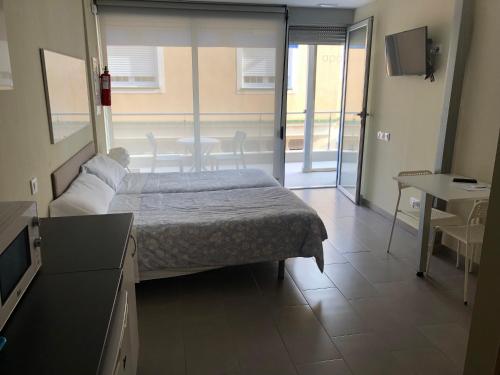 Cet appartement comprend une chambre avec un lit, une cuisine et une table. dans l'établissement Apartamentos Turisticos Maria Guerrero, à Cap de Palos