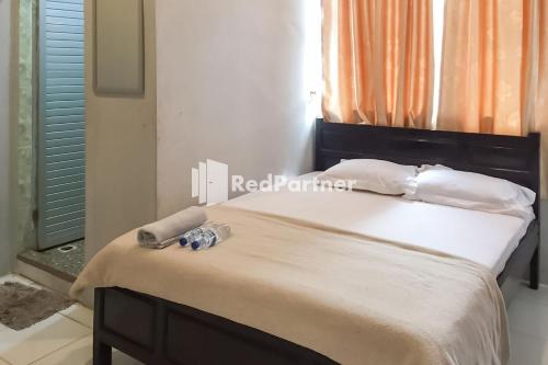 Кровать или кровати в номере Aquino Marito Homestay Mitra RedDoorz