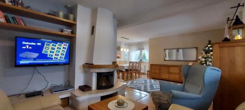 sala de estar con chimenea y TV en Lawendowe Wzgórze 21 en Węgierska Górka