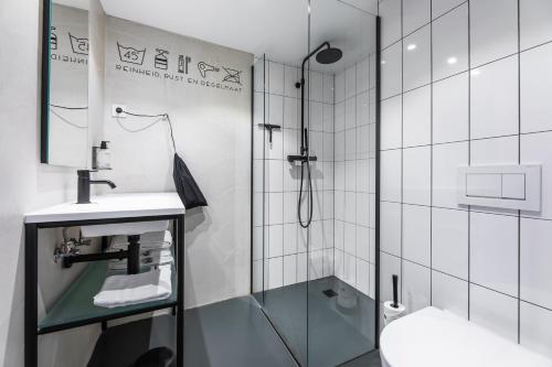 a bathroom with a shower and a sink and a toilet at Gooiland Hotel in Hilversum