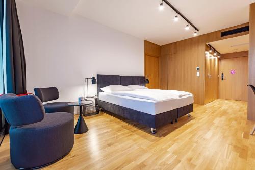 ein Schlafzimmer mit einem Bett und einem Stuhl in der Unterkunft VacationClub – Seaside Apartament 505 in Kołobrzeg