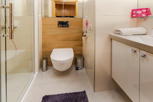a bathroom with a toilet and a shower and a sink at VacationClub – Seaside Apartament 506 in Kołobrzeg