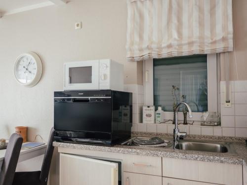 a kitchen with a sink and a microwave at Beachcomber House A in Friedrichskoog
