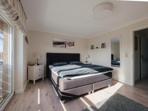 a bedroom with a bed and a large window at Beachcomber House A in Friedrichskoog