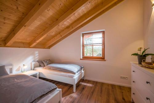 a attic bedroom with a bed and a window at Ferienwohnung Hofmann in Kiefersfelden