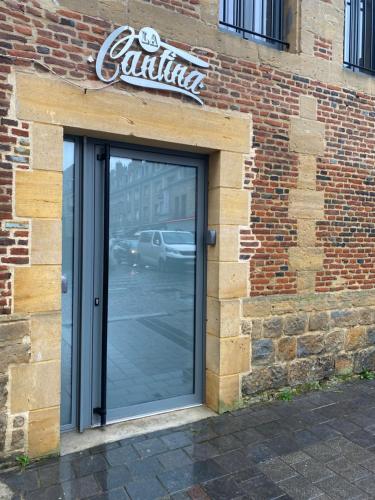 una porta a vetri di un edificio con un cartello sopra di la cantina a Charleville-Mézières