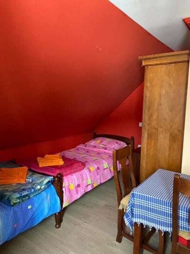 a bedroom with two beds and a red wall at Apartments Razvršje in Žabljak