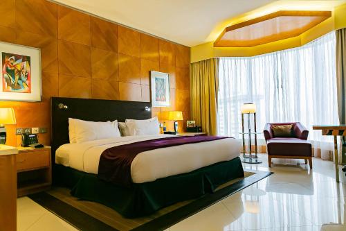 a hotel room with a bed and a chair at Lagos Continental Hotel in Lagos