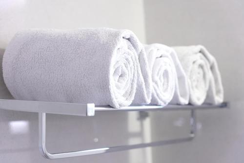 a row of towels on a shelf in a bathroom at M Stays in Chennai
