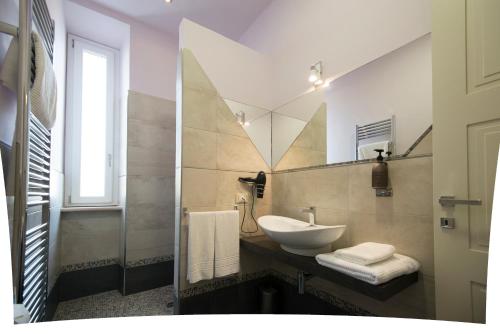 W łazience znajduje się umywalka i lustro. w obiekcie Halex room&food w mieście Nettuno
