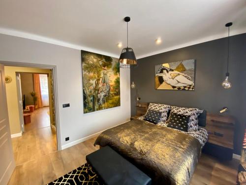 ein Wohnzimmer mit einem Bett und Gemälden an der Wand in der Unterkunft Apartament Golden Art in Mielec