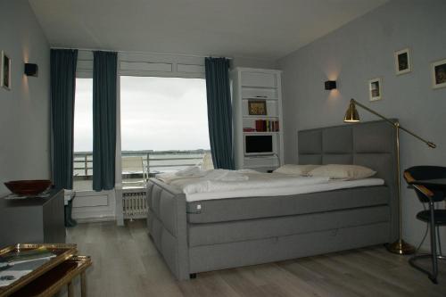 a bedroom with a bed and a large window at Meer-Studio in Glücksburg