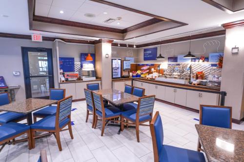 a restaurant with tables and chairs and a counter at Holiday Inn Express and Suites Springfield Medical District by IHG in Springfield