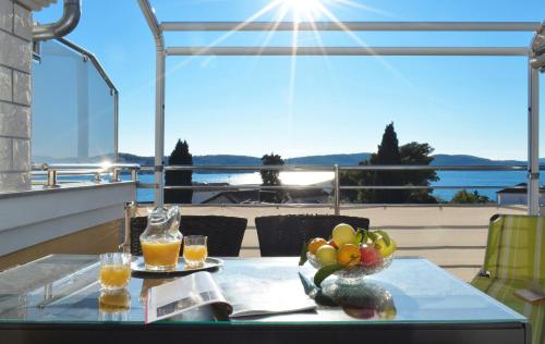 a table with a bowl of fruit and two glasses of juice at Villa Klaudia in Trogir