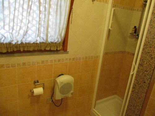 een badkamer met een douche en een toiletpapierdispenser bij Maison de vacances dans un village de vacances à100 m. de la plage in Badesi