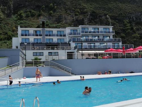 un grupo de personas en la piscina de un hotel en Calamar Hotel en São Vicente