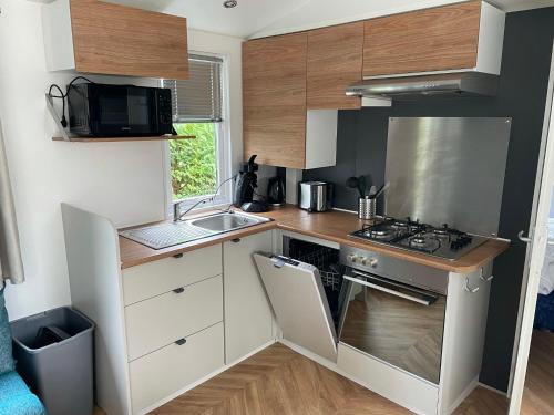 a small kitchen with a stove and a sink at Renesse Chalet in family friendly area in Renesse