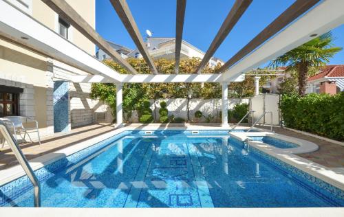 an indoor swimming pool with a large pergola at Villa Klaudia in Trogir