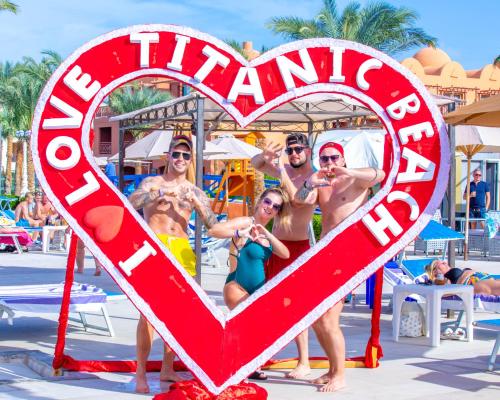 een groep mensen die poseren voor een hartvormig bord bij Titanic Beach - Families and Couples only in Hurghada