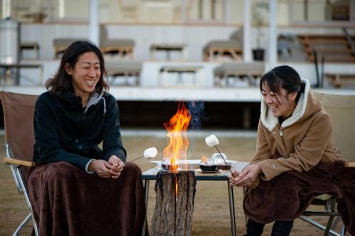 two women sitting around a table with a fire at WAKKA in Imabari