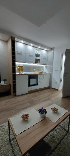 a living room with a table and a kitchen at Apartman Vesna in Nova Varoš