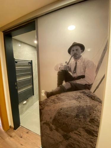 an old photo of a man sitting on a bed at GRUBERS, Hotel Appartments Gastein in Bad Gastein