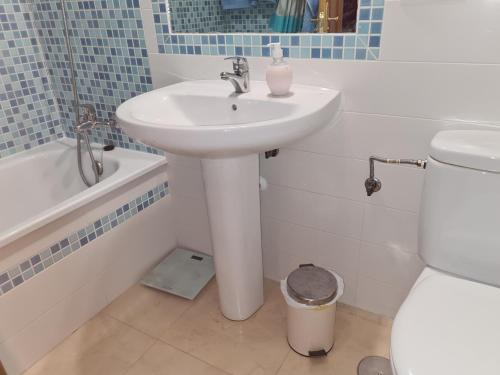 Baño blanco con lavabo y aseo en APARTAMENTO BONITO EN PINAL DEL MAR NERJA en Nerja