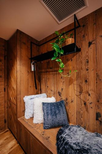 a room with wooden walls and a bench with pillows at JOHAN HOTEL in Zlín