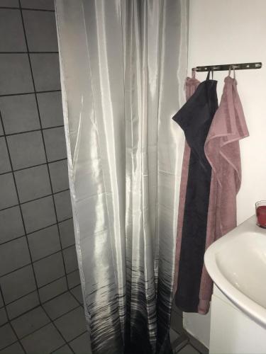 a shower curtain in a bathroom next to a sink at Hus ved skov in Ejby