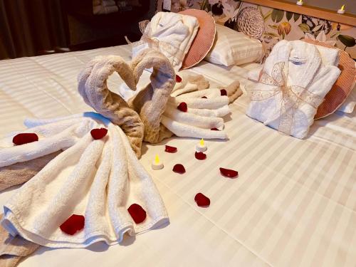 a bed with towels and hearts on it at Le Bois Dormant-Hôtel Restaurant & Spa Logis Hôtel in Champagnole