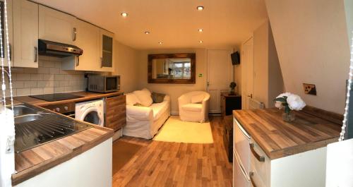 a small kitchen and living room with a couch at The Artist’s Hideaway. in Woking