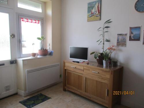 a living room with a television on a wooden dresser at maison située à 300 mètres de la thalasso de Pornic et des plages in Pornic