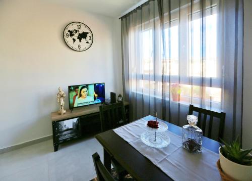a dining room with a table and a clock on the wall at New studio apartman Emda u centru Splita in Split