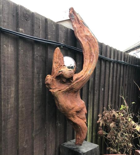 a statue of a cat leaning against a fence at The Artist’s Hideaway. in Woking