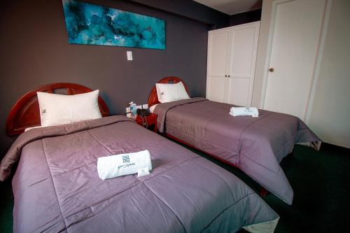 two beds sitting next to each other in a room at Saint Germain Hotel in Trujillo