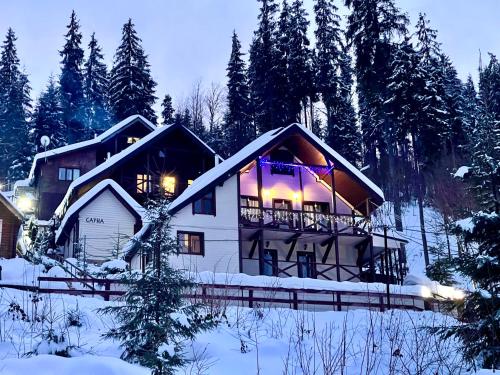 una casa nella neve con le luci accese di Котедж Chalet Adriana a Bukovel